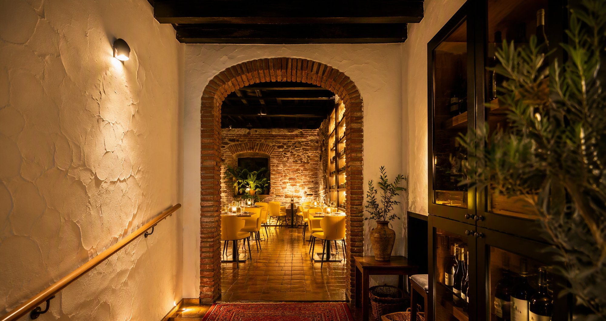 El comedor de Casa La Gloria, arco de ladrillo y vinoteca de la antigua ultramarinos desde 1927